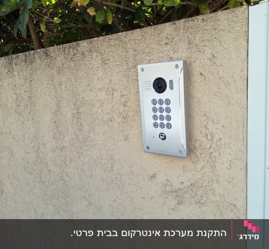 Intercom with camera and keypad on wall